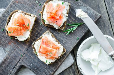 Sağlıklı kahvaltı. Tahta tahtada çavdar ekmeği, somon balığı ve krem peynirli tost. Sağlıklı atıştırmalık konsepti. Üst görünüm.