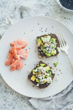Somon balıklı sağlıklı kahvaltı ve çavdar ekmekli tost, avokado ve küflü peynir..