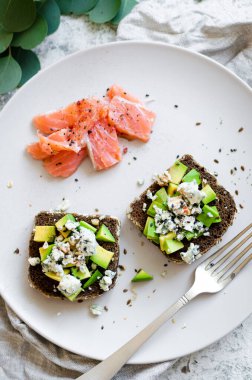 Somon balıklı sağlıklı kahvaltı ve çavdar ekmekli tost, avokado ve küflü peynir..