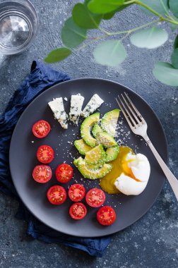 Avokado, domates ve mavi peynirli sağlıklı bir kahvaltı. Keto diyet gıda konsepti. Üst görünüm.