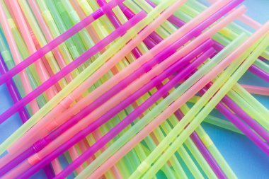 Mavi arka planda renkli plastik pipetler. Plastik pipet içmeye hayır de. Sıfır sürdürülebilir yaşam konsepti. Eko dostu plastik eşyalar. Tekrar kullan, azalt, reddet. Üst görünüm.