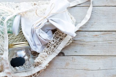 Yeniden kullanılabilir pamuk torbası ve tahta arka planda cam kavanozlar. Sıfır atık. Sürdürülebilir yaşam, plastiksiz konsept. Eko dostu plastik eşyalar. Üst Manzara. Boşluğu kopyala.