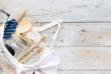 Sıfır atık. Pamuk torbaları, cam kavanoz, bambu çatal bıçak takımı ve tahta arka planda diş fırçası. Sürdürülebilir yaşam. Eko dostu plastik eşyalar. Üst Manzara. Boşluğu kopyala.
