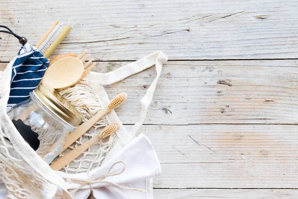 Sıfır atık. Pamuk torbaları, cam kavanoz, bambu çatal bıçak takımı ve tahta arka planda diş fırçası. Sürdürülebilir yaşam. Eko dostu plastik eşyalar. Üst Manzara. Boşluğu kopyala.