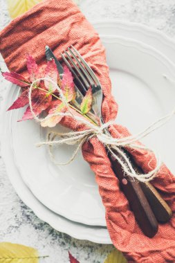 Şükran Günü sonbahar sofra takımı ve gri arka planda sonbahar yaprakları. Şükran Günü tatili konsepti. Üst görünüm.