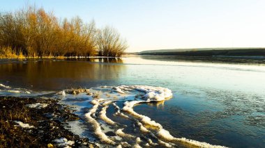 Nehrin kıvrımlarındaki karla kaplı okun ince bir buz tabakası var..