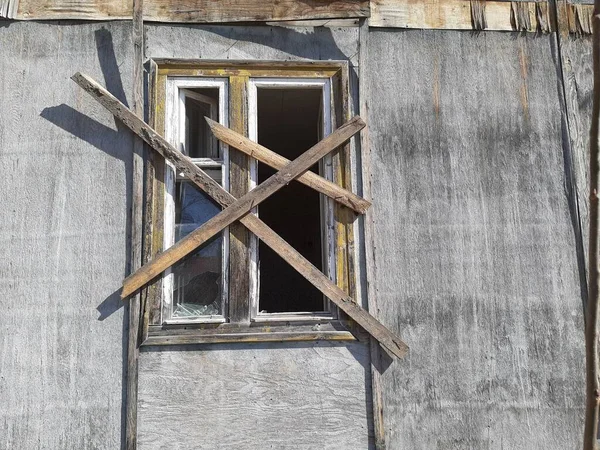 Ev yıkım altındadır. Eski ev panellerden yapılmıştır. Kırık ve tahta kaplı camlar. Güneşli bir gün. Yaşlılıktan sonra yıkım.