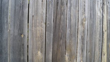 Ucunda çivi izleri olan gri tahtalar. Sokak, gündüz. Arkaplan tahtalardan yapılmıştır.