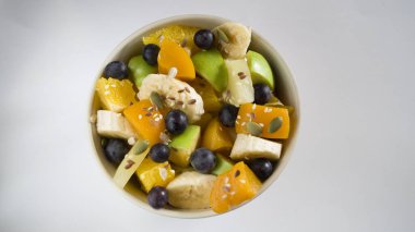 Düşük kalorili lezzetli tatlılar kavramı. Bir kase meyve salatası. Doğal işlenmemiş organik gıda. Hafif arka planda lezzetli bir atıştırmalık. Elma yeşili ve ölçü bandı.