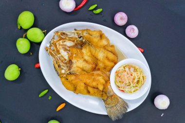 Pla Tod Num plağı. Balık soslu kızarmış deniz levreği, kızarmış balık, Tayland usulü baharatlı mango sosu.