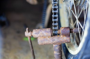 Tamirci motosiklet zincirini kesip motosikleti tamir ediyor..