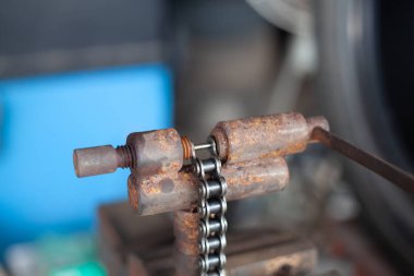 Tamirci motosiklet zincirini kesip motosikleti tamir ediyor..