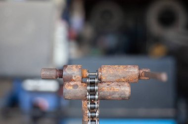 Tamirci motosiklet zincirini kesip motosikleti tamir ediyor..