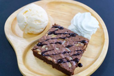 Tahta tabakta bademli çikolatalı pasta ve dondurma.