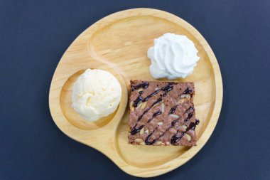 Tahta tabakta bademli çikolatalı pasta ve dondurma.