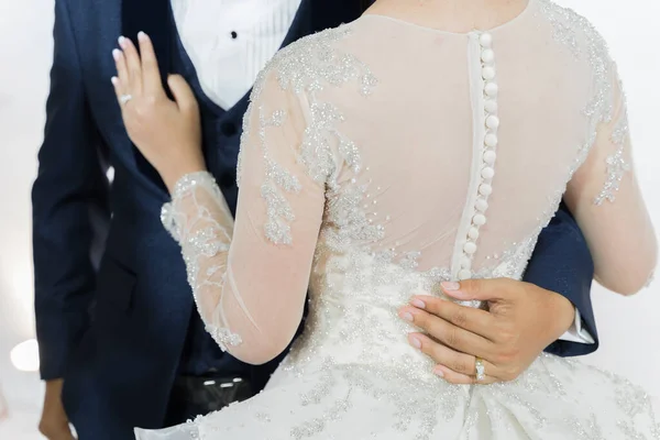 The groom\'s hand hugs the bride\'s waist in wedding ceramony.feelling in love