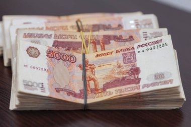 Masaya beş bin rublelik banknotlar serilmiştir.