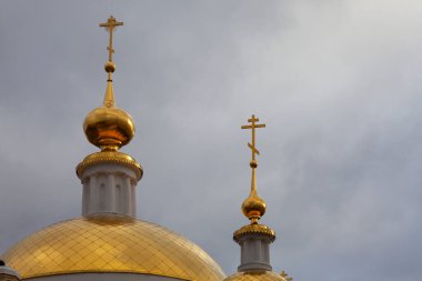 Ortodoks Kilisesi 'nin yaldızlı kubbeleri yağmurlu gökyüzünün arka planına karşı.