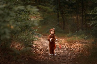 a child in the form of a fox walks in the woods