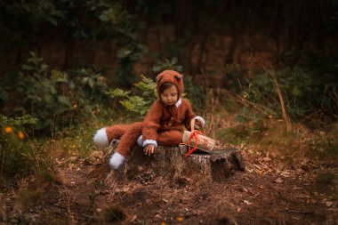 a child in the form of a fox walks in the woods