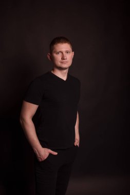 Siyah arka planda kızıl saçlı bir adamın portresi. kısa saç