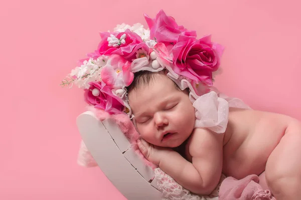 可愛い新生児は花と寝ています ピンクの背景で — ストック写真
