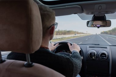 Bir adamın hafif bir virajdan geçerken çekilmiş genel fotoğrafı. Adam sürüyor.