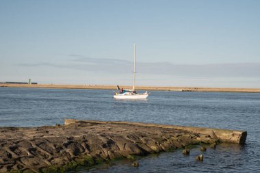 Dağın arka planına karşı denizde yüzen bir tekne. Gemi denizde seyrediyor...