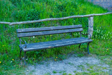 Eski ağaçlar ve patikalarla dolu yaz parkındaki bankta. Ormandaki banka.