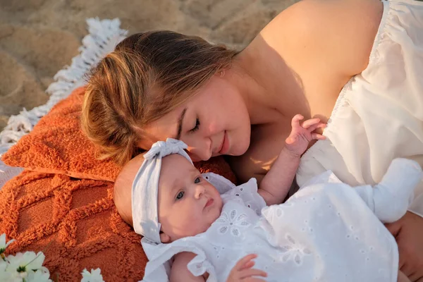 Máma Novorozeným Dítětem Leží Pláži Bílé Šaty Květiny Leží Poblíž — Stock fotografie