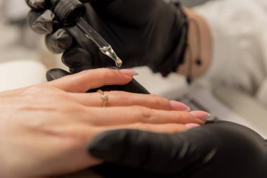 Manikür. Bir manikürcünün işyeri. Manikürcü müşteriye tırnaklarını boyuyor..