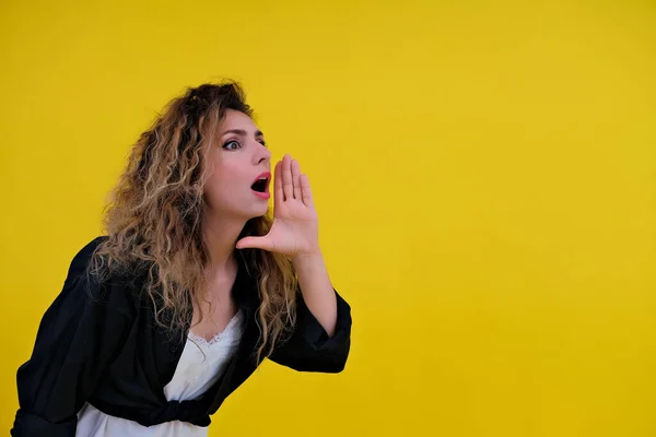 Close-up portrait of a beautiful girl on a yellow background. woman screaming and advertising , place for advertising. Advertising concept.