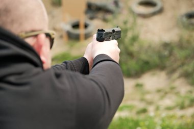 Bir adam elinde silah tutuyor. tabanca atış egzersizleri