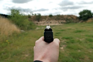 El ateşli bir silah tutuyor. Tabanca. Atış poligonunda eğitim