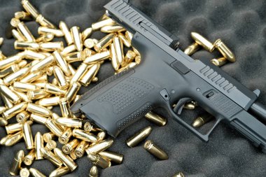 Tabanca 9 mm 'lik masanın üzerinde duruyor. Silah fişeklerin üzerinde. askeri silah