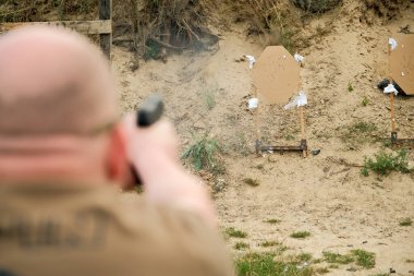 Bir adam elinde silah tutuyor. tabanca atış egzersizleri