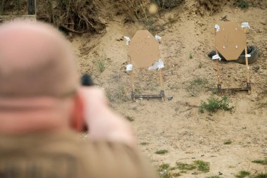 Bir adam elinde silah tutuyor. tabanca atış egzersizleri