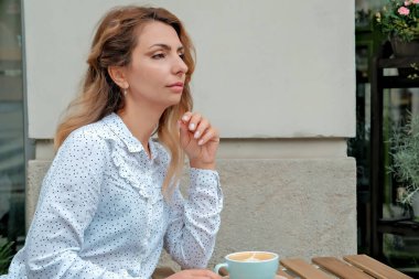 Sokakta kahve içen bir kız. Sokak Kafe 'si. Güzel kız ve kahve..