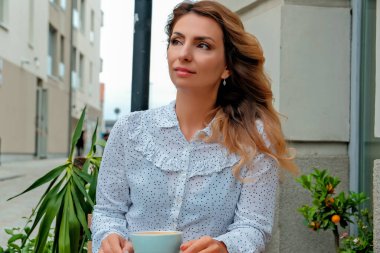 Sokakta kahve içen bir kız. Sokak Kafe 'si. Güzel kız ve kahve..