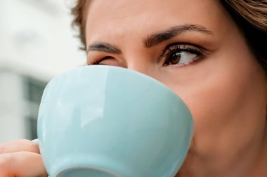 Kadın eli bir fincan kahve tutar. Bir fincan yakın çekim kahve.