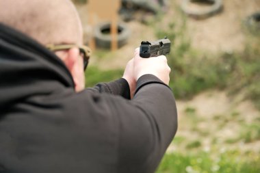 Bir adam elinde silah tutuyor. tabanca atış egzersizleri