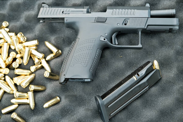 the pistol lies on the table 9 mm. the gun is on the cartridges. military weapon