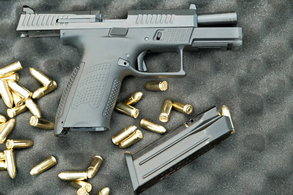 the pistol lies on the table 9 mm. the gun is on the cartridges. military weapon