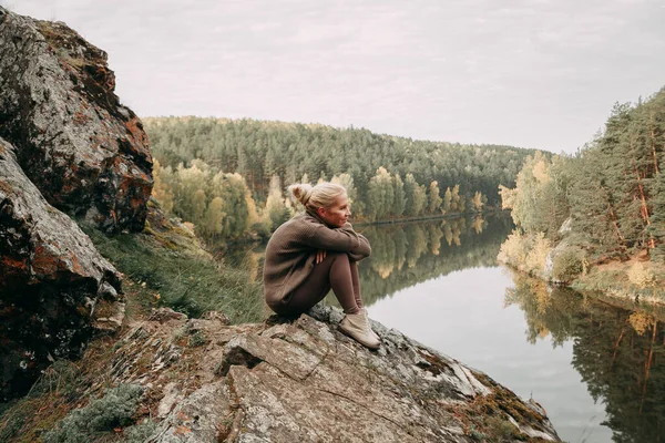Una joven rubia camina en otoño en las montañas con vistas al río y al bosque — Foto de Stock
