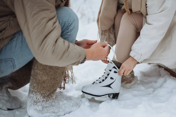 Man tying skates to his girlfriend. Winter romance, love, wintertime — Stock Photo, Image