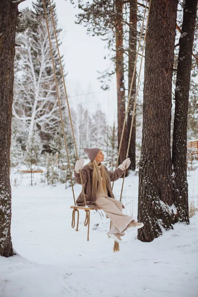 Young girl swinging on a swing in winter — Photo