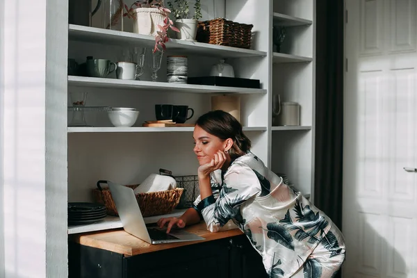 Молода дівчина працює дистанційно вдома за допомогою ноутбука — стокове фото