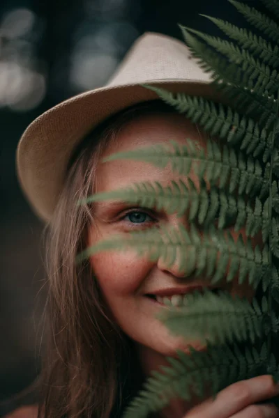 Chica joven con pecas sin maquillaje en el bosque con un helecho — Foto de Stock