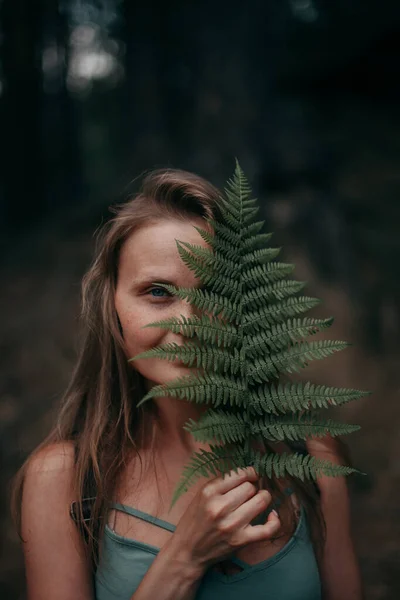 Chica joven con pecas sin maquillaje en el bosque con un helecho — Foto de Stock