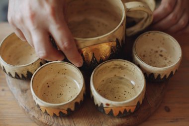 Orta yaşlı bir kadın çömlekçilik atölyesinde çevre dostu kil çatalıyla